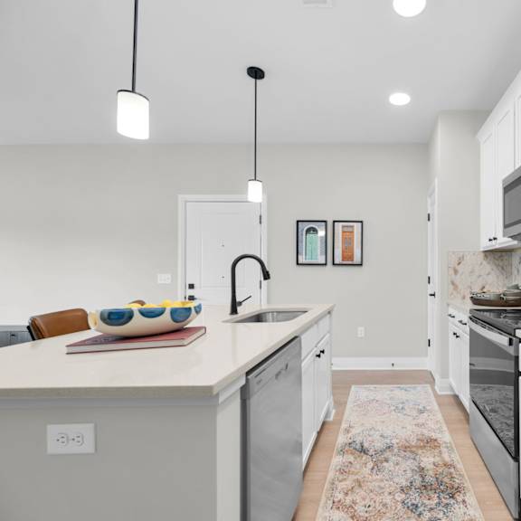 a modern kitchen with a white countertop and stainless steel appliances.