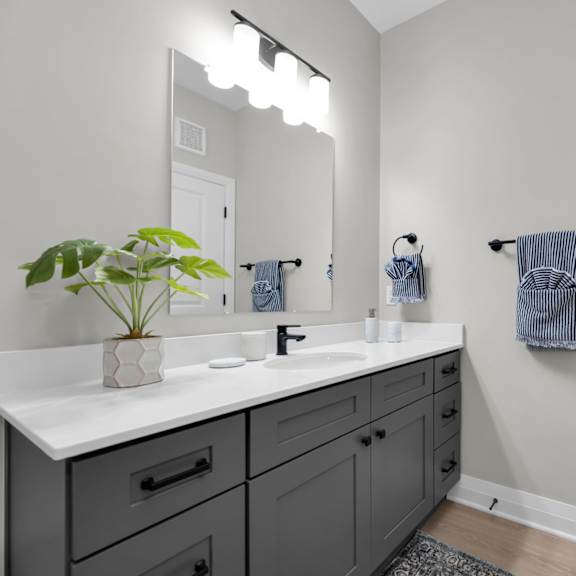 a bathroom with a white counter top and a mirror above it.