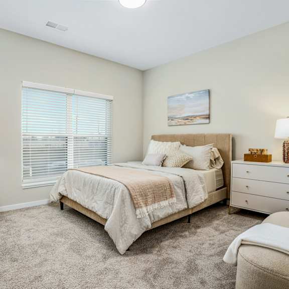 a bedroom with a bed and a dresser and a window