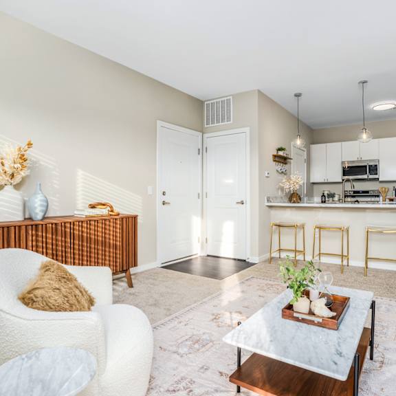 a living room with a couch and a coffee table in front of a kitchen