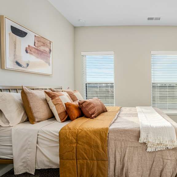 a bedroom with a bed and two windows
