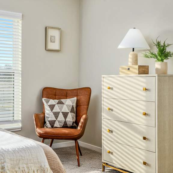 a bedroom with a bed and a chair and a dresser