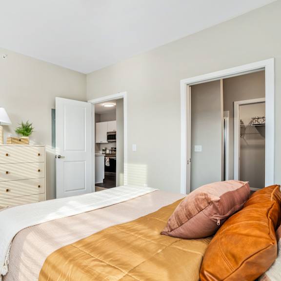 a bedroom with a bed and a chair and a closet