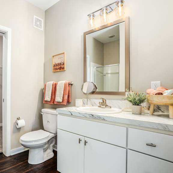 a bathroom with a toilet sink and shower and a mirror