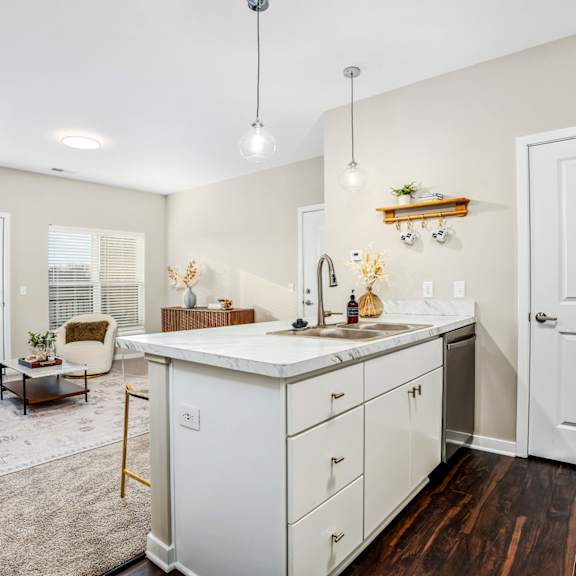 a renovated kitchen with white cabinets and a living room