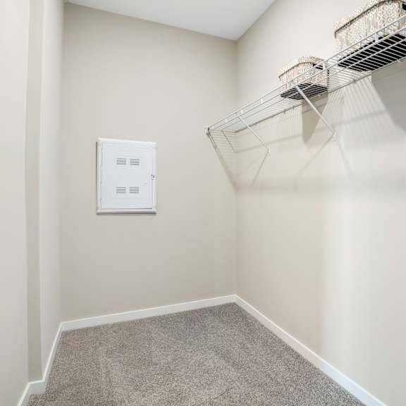 an empty closet with a wire basket hanging on the wall