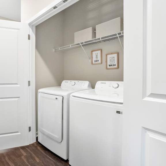 a spacious laundry room with washer and dryer and a door to the bathroom
