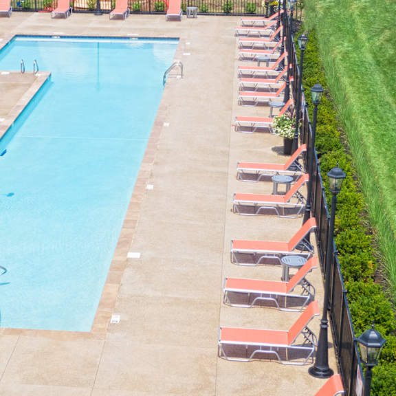 an aerial view of a swimming pool with chairs around it