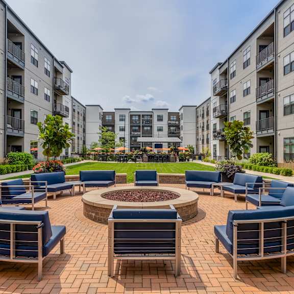 an outdoor lounge area with a fire pit at an apartment complex