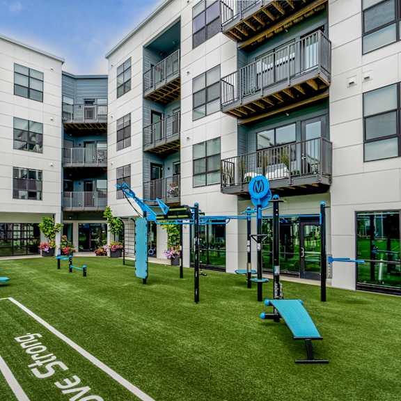 an apartment building with a playground and benches in front of it