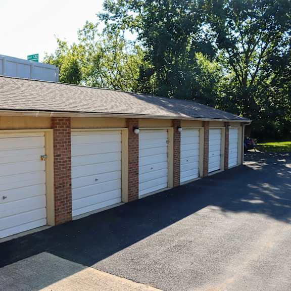a row of white garage doors on a brick building