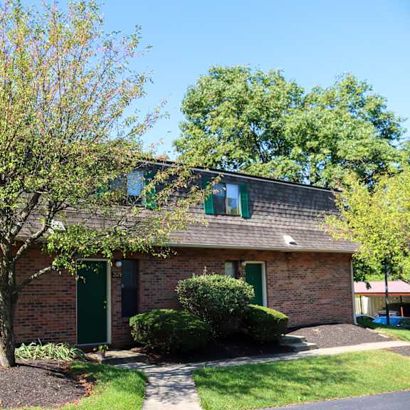 a brick house with a tree in front of it