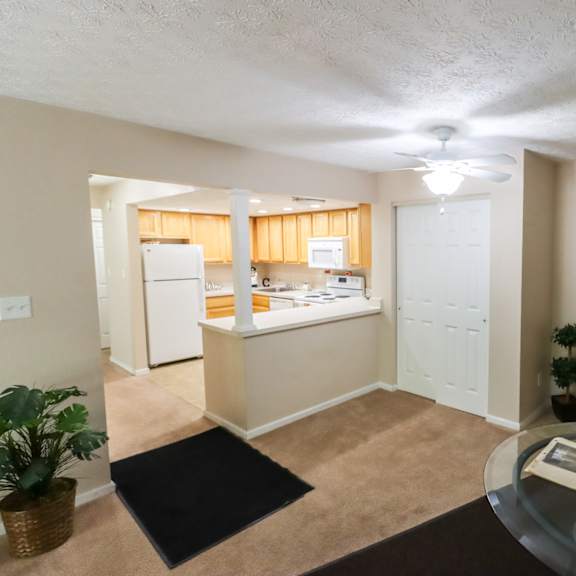 an open kitchen and living room with a glass table