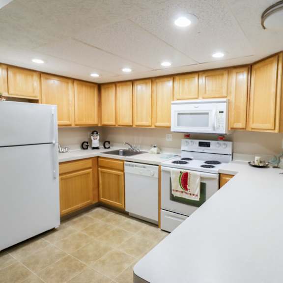a kitchen with white appliances and wooden cabinets