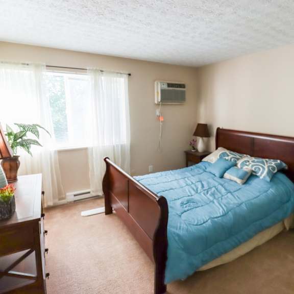 a bedroom with a bed and a dresser and a window