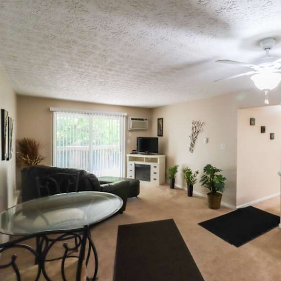 an open living room with a kitchen and a ceiling fan