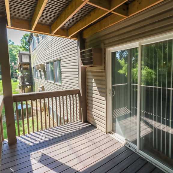 a covered porch with glass doors on a house