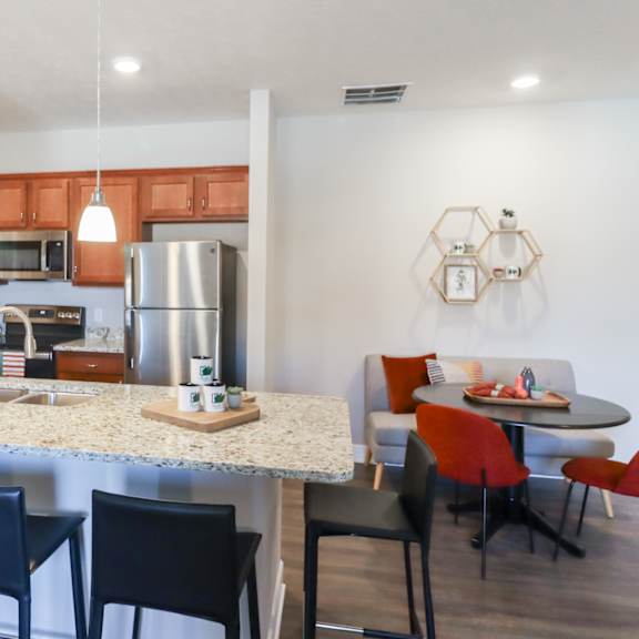 a kitchen and dining area with a granite counter top and stainless steel appliances