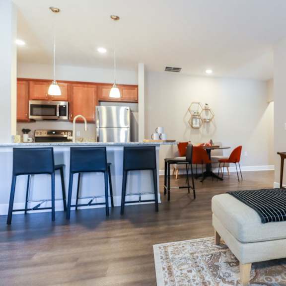 a living room with a couch and a kitchen with a table and chairs