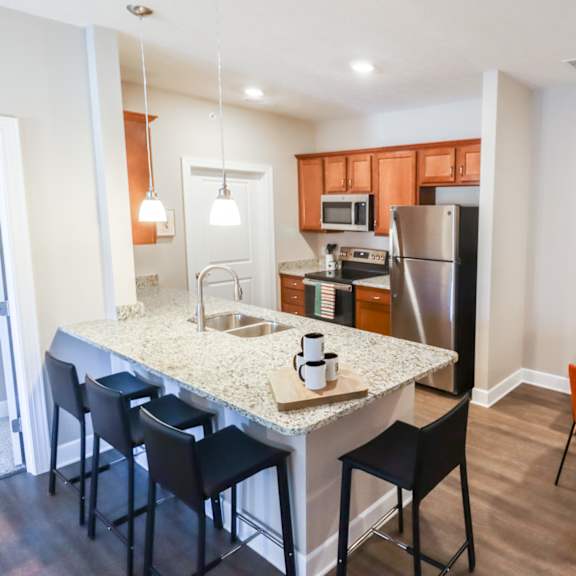 a kitchen and dining area with a granite counter top and stainless steel appliances
