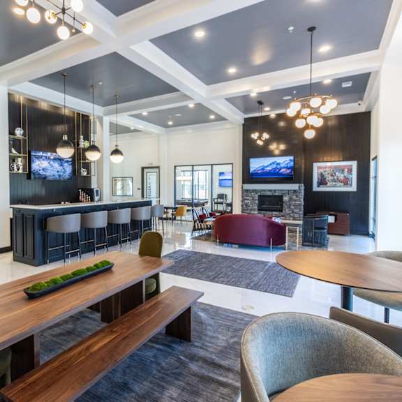 a communal area with tables and chairs and a fireplace