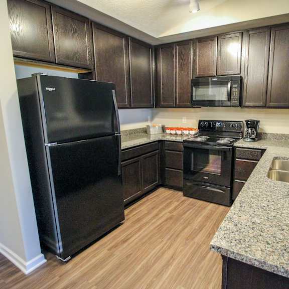 a kitchen with black appliances and a granite counter top