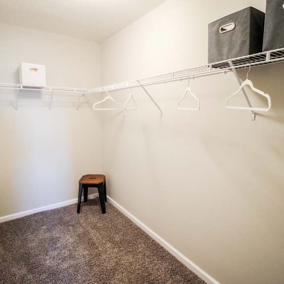 a walk in closet with a small stool in a 555 waverly unit