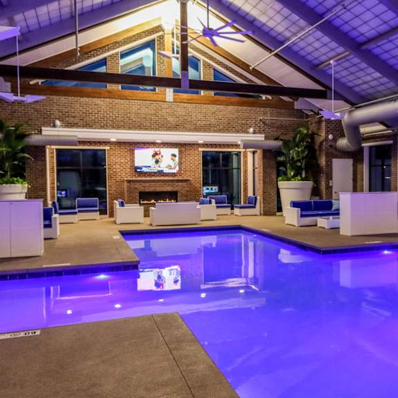 a large indoor pool with lounge chairs and a fireplace