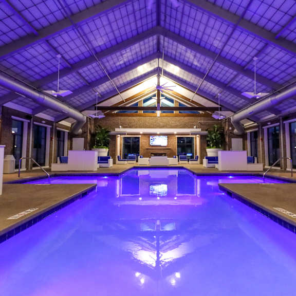 a large indoor swimming pool with a glass ceiling