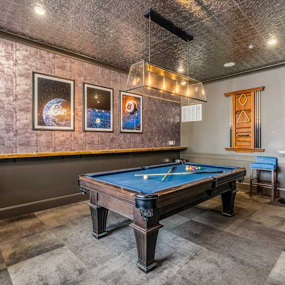 a game room with a pool table and a bar