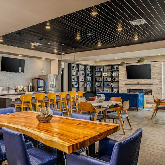 a dining room with tables and chairs and a bar and television