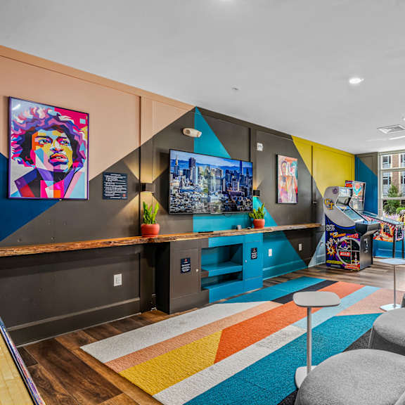 a living room with couches and chairs and a play area with a video game