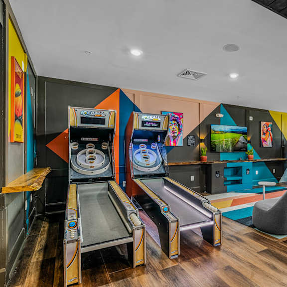 a game room with a bunch of arcade games and chairs