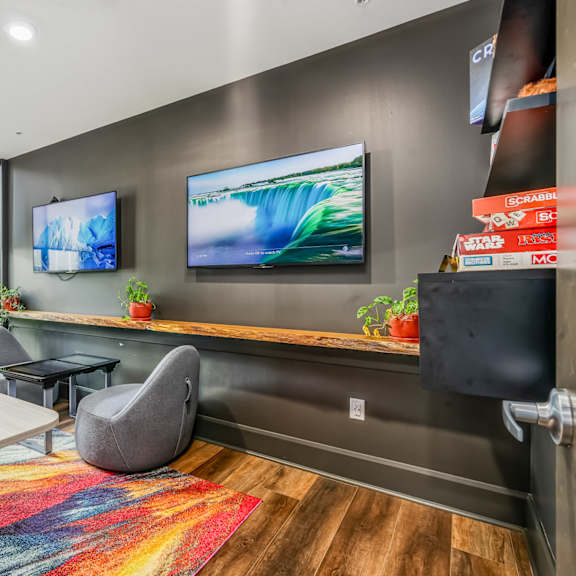 a conference room with a desk and two televisions on the wall