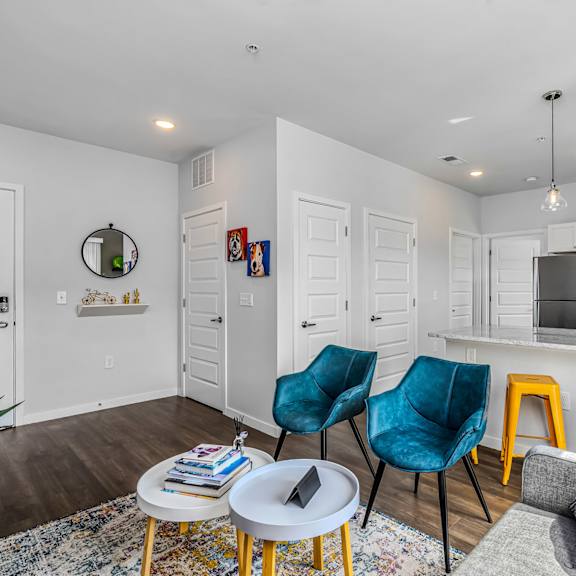 a living room with a kitchen with a bar and stools