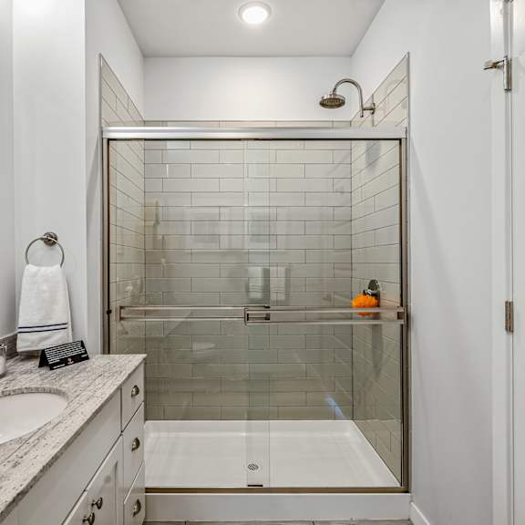 a bathroom with a shower and a sink and a mirror