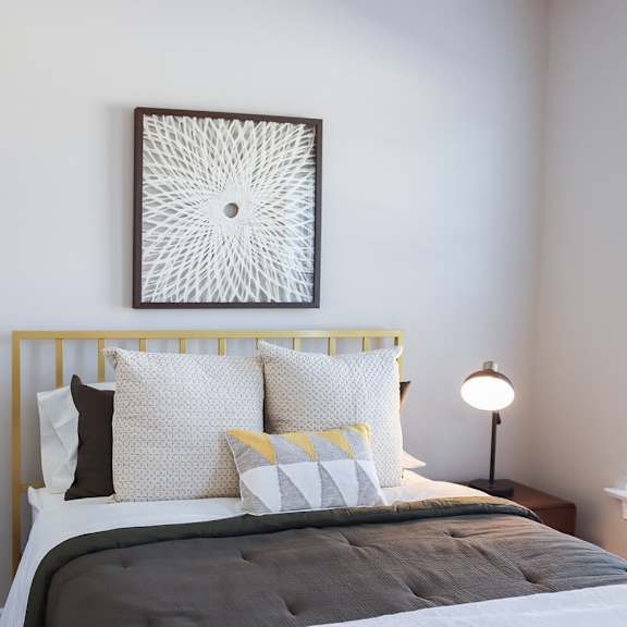 a bedroom with a bed and a painting on the wall