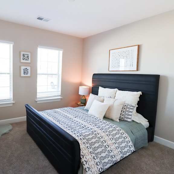a bedroom with a bed and two windows