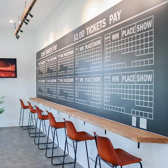 a large chalkboard menu on the wall of a bar with chairs