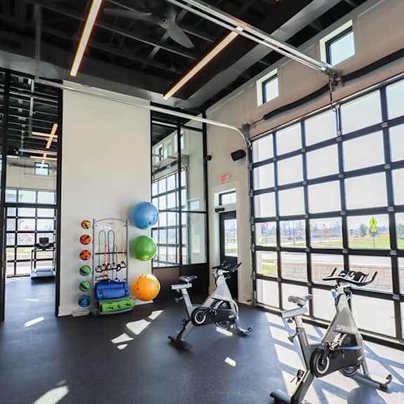 a workout room with exercise bikes and windows