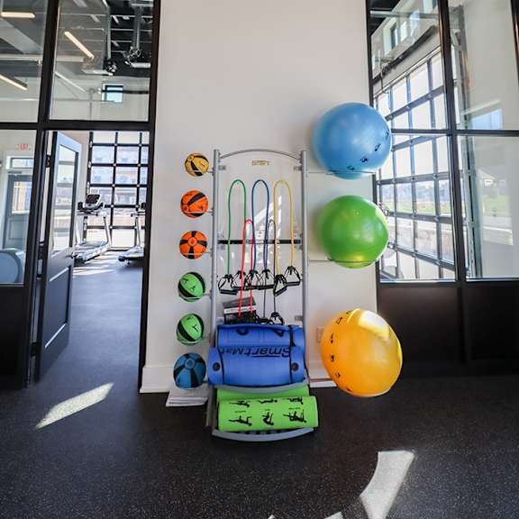 a white wall with a bunch of balloons and a trolley