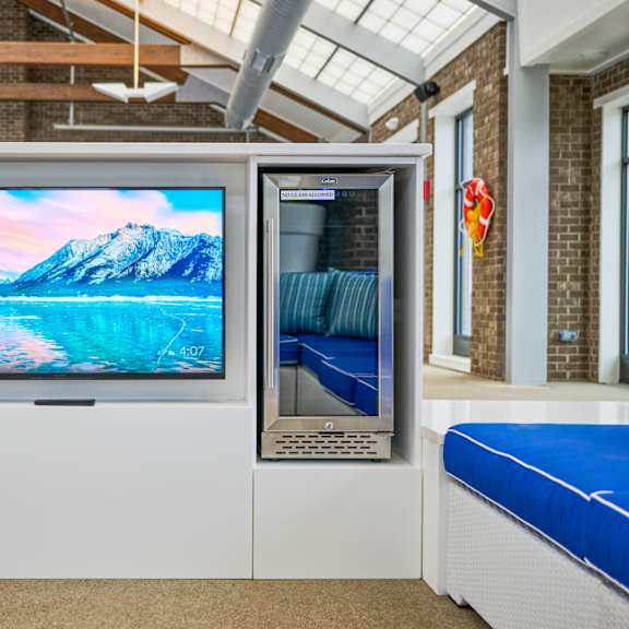 a television on a stand in front of a pool
