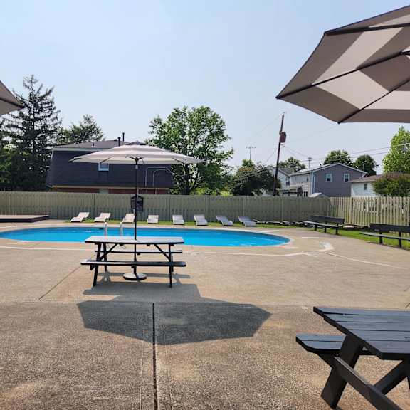 our community has a pool and picnic tables with umbrellas