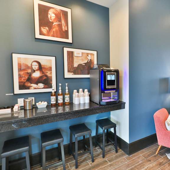 a hotel lobby with a bar with chairs and a coffeemaker