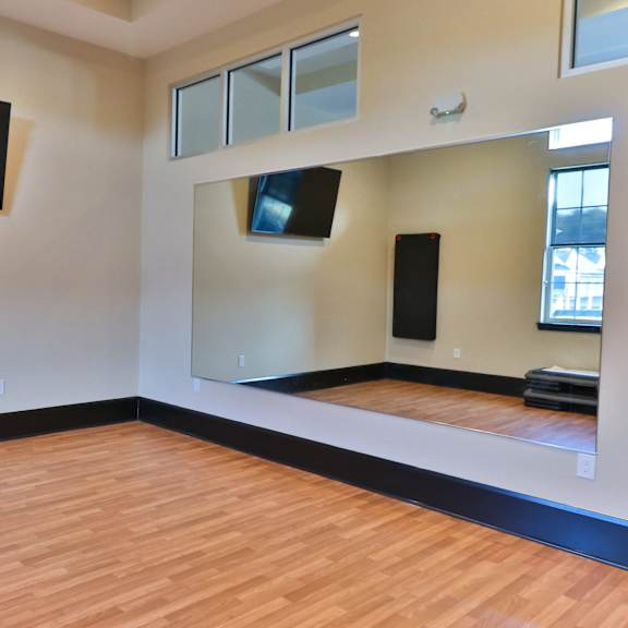 an empty room with wood floors and televisions on the wall