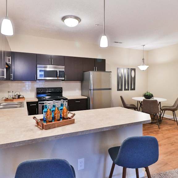 the view of a kitchen and dining room with a large counter top with a bar