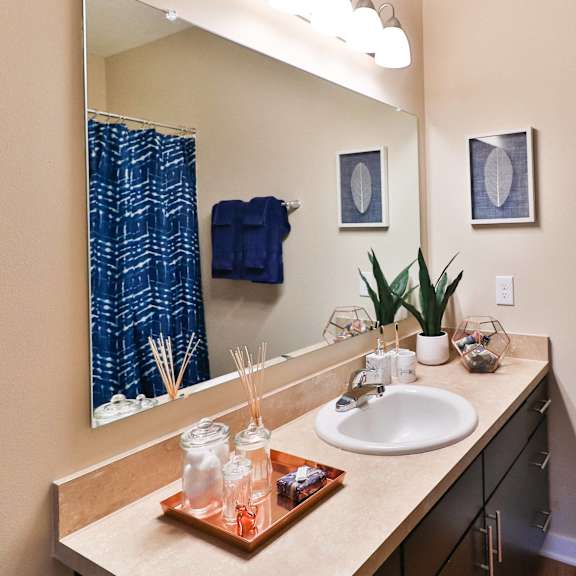 a bathroom with a sink and a mirror and blue towels