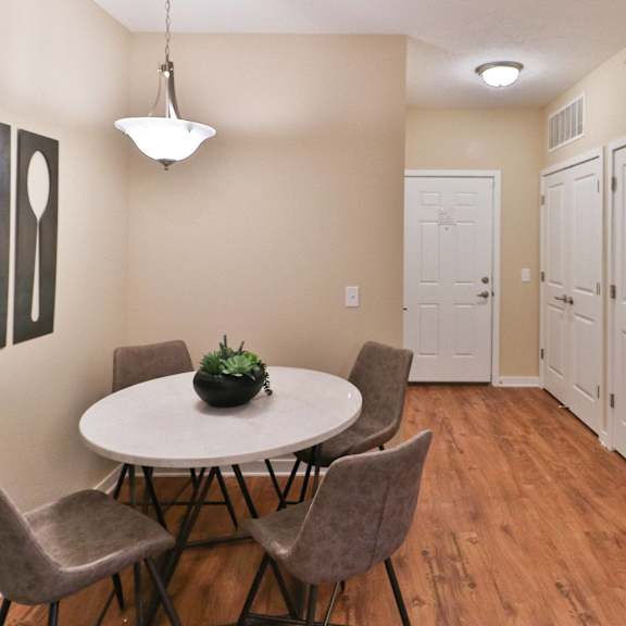 a dining room with a table and chairs and a hallway with white doors