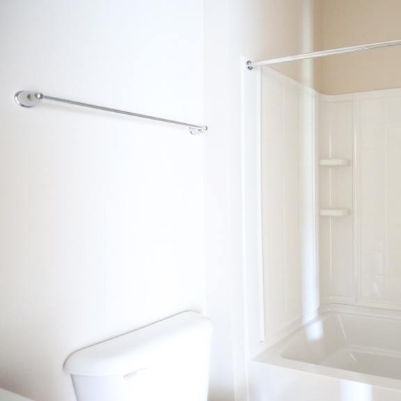 a white bathroom with a shower and a toilet