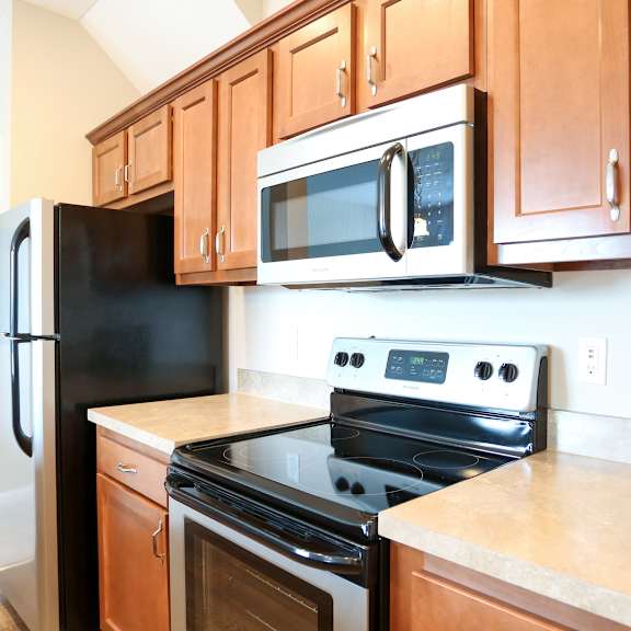a kitchen with wood cabinets and black appliances and a black refrigerator